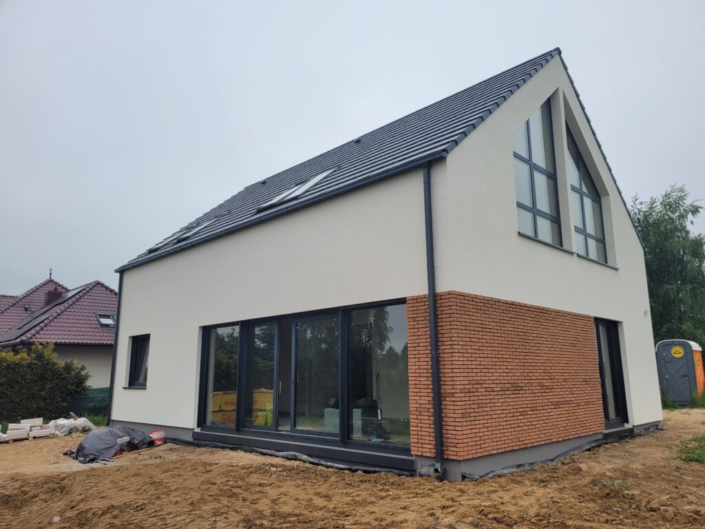 Firma budowlana Poznań - dom z użytkowym poddaszem, dachem dwuspadowym i garażem