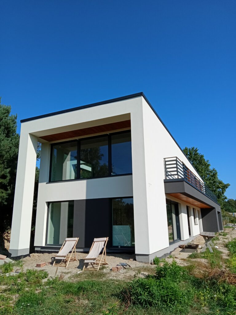 Budowa domów energooszczędnych Warszawa - dom piętrowy z dachem płaskim i garażem