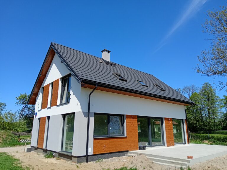 Budowa domów energooszczędnych Warszawa - dom z użytkowym poddaszem, dachem dwuspadowym i garażem